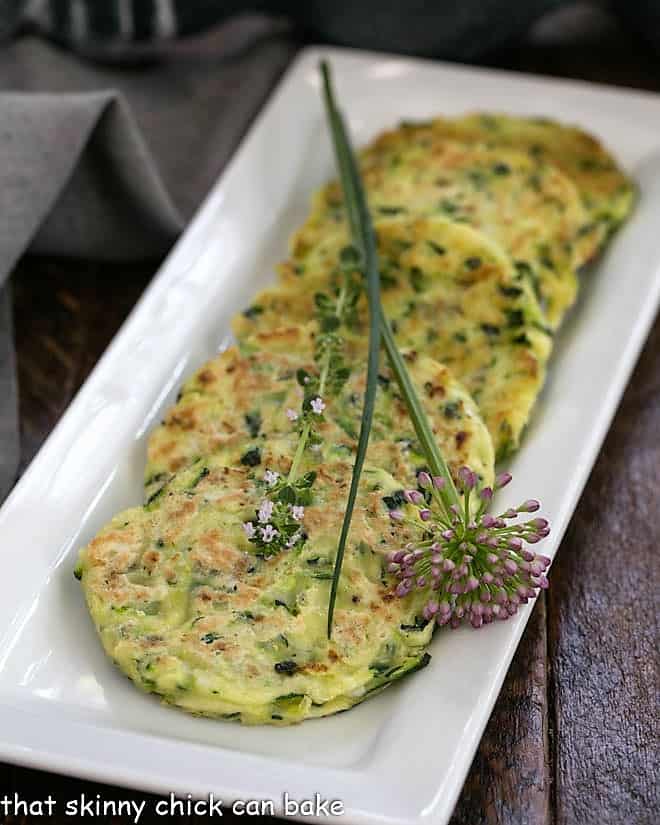 Zucchini fritters on a white rectangle tray.