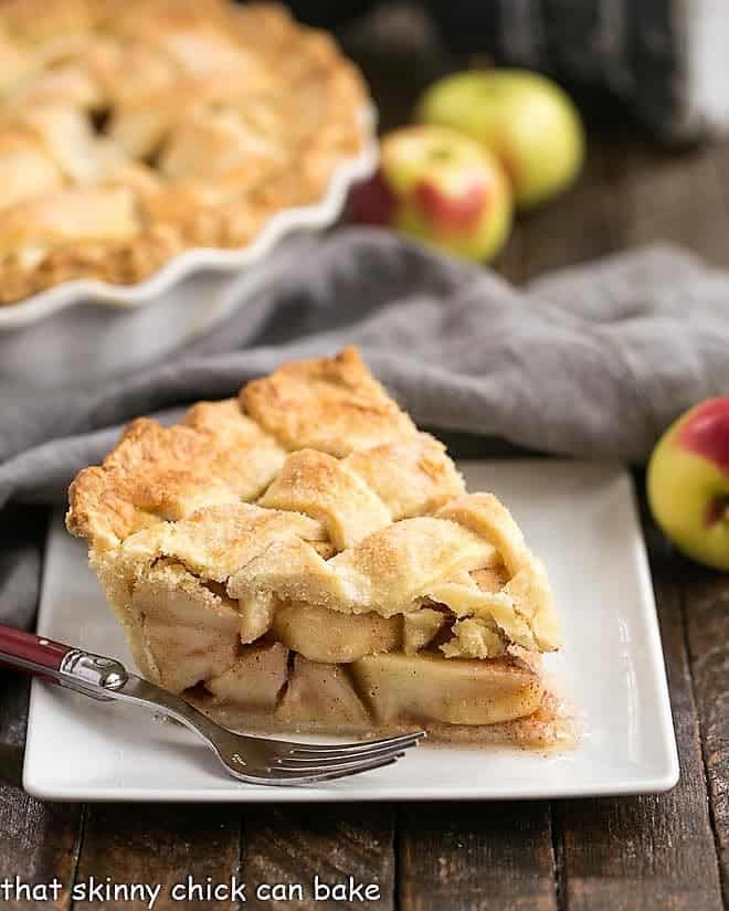 Homemade Apple Pie - A cinnamon spiced apple pie with a flaky lattice crust! A couple tricks make this the best recipe for a classic apple pie! Perfect Apple Pie slice on a square white plate.