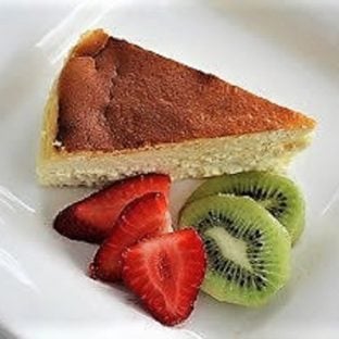 Slice of Ricotta Cheesecake with Homemade Ricotta on a white plate