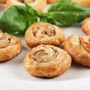 Prosciutto Gruyère Pinwheels made with homemade puff pastry on a white serving platter