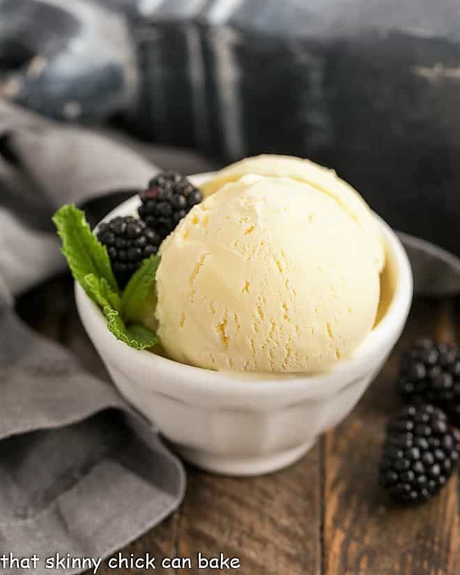 Dreamy White Chocolate Ice Cream -A rich, luscious ice cream enhanced with melted white chocolate! White Chocolate Ice Cream in a white bowl with blackberries and mint.