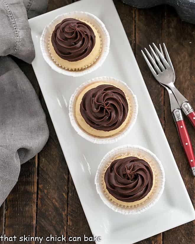 Overhead view of 3 Boston Cream Pie Cupcakes on a narrow white platter