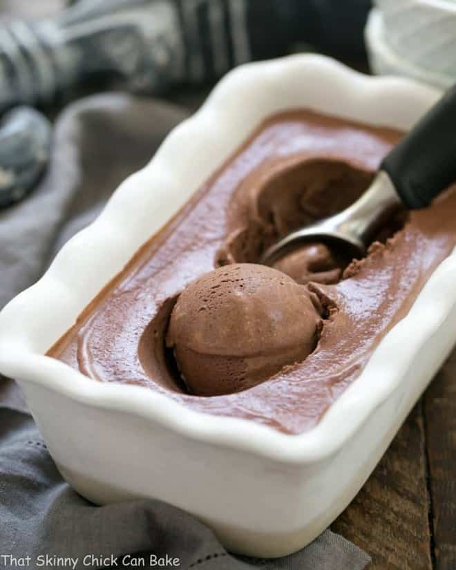 Chocolate Ice Cream with Fudge Sauce in a freezer dish with an ice cream scoop