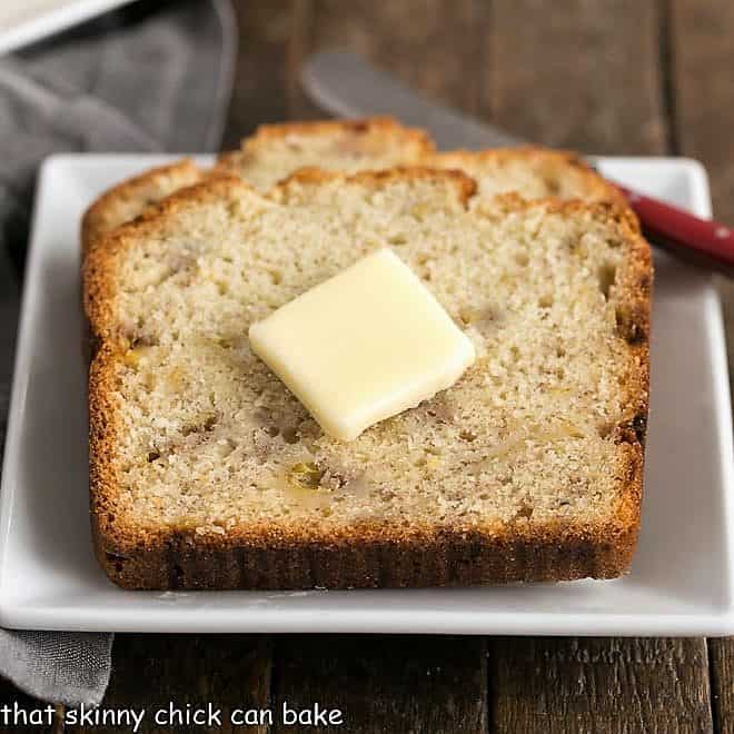 Buttermilk Banana Bread on a square white plate with a red handled knife.