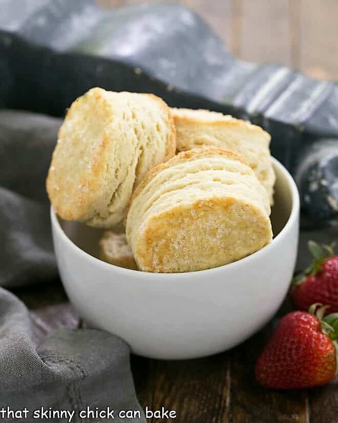 Classic Strawberry Shortcake - tender flaky biscuits topped with sweet, juicy berries and freshly whipped cream for a magnificent spring or summer dessert Bowl of flaky shortcake biscuits