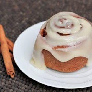 Frosted Cinnamon Roll on a white plate