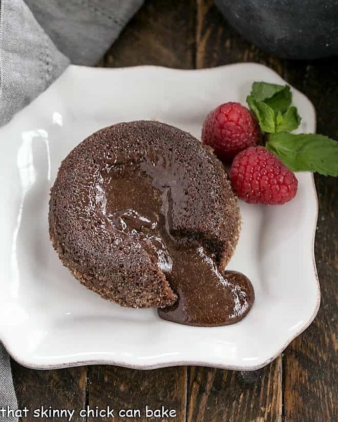 A molten lava cake with a forkful of cake on a white plate.