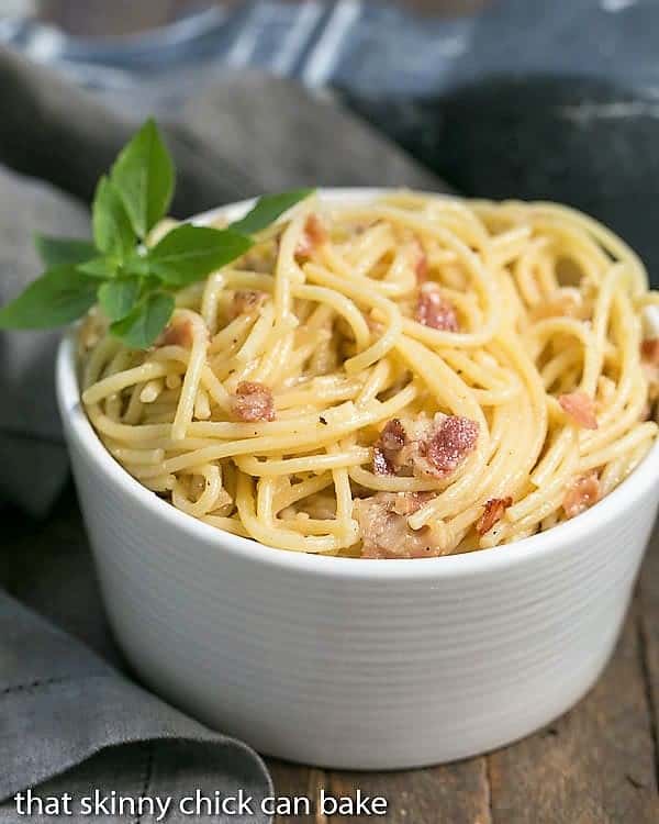 A white ceramic bowlful of spaghetti carbonara.