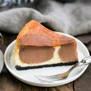 A slice of polka dot cheesecake on a white plate