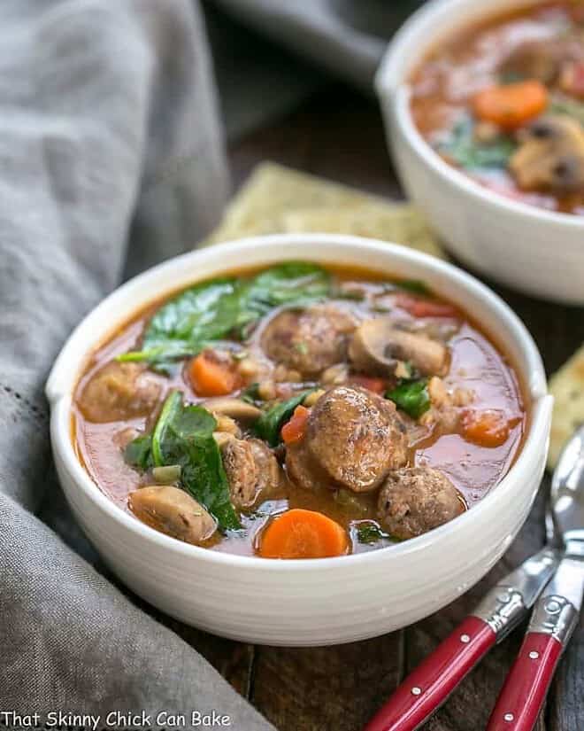 Comforting, rustic farro soup with a taste of Italy in every spoonful Rustic Farro Soup in two white soup bowls with spoons and crackers.