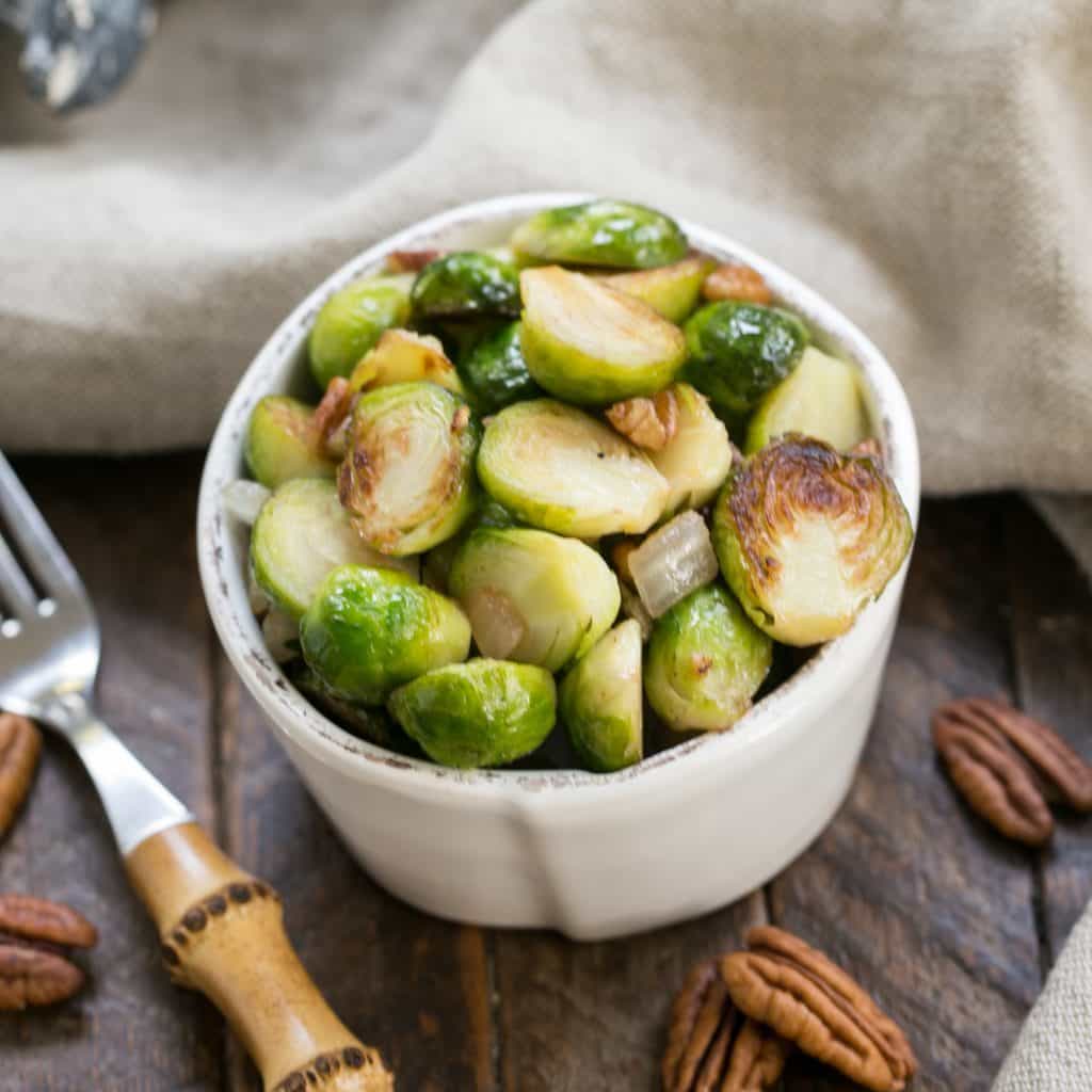 Overhead view of a small white bowl of sauteed Brussels sprouts
