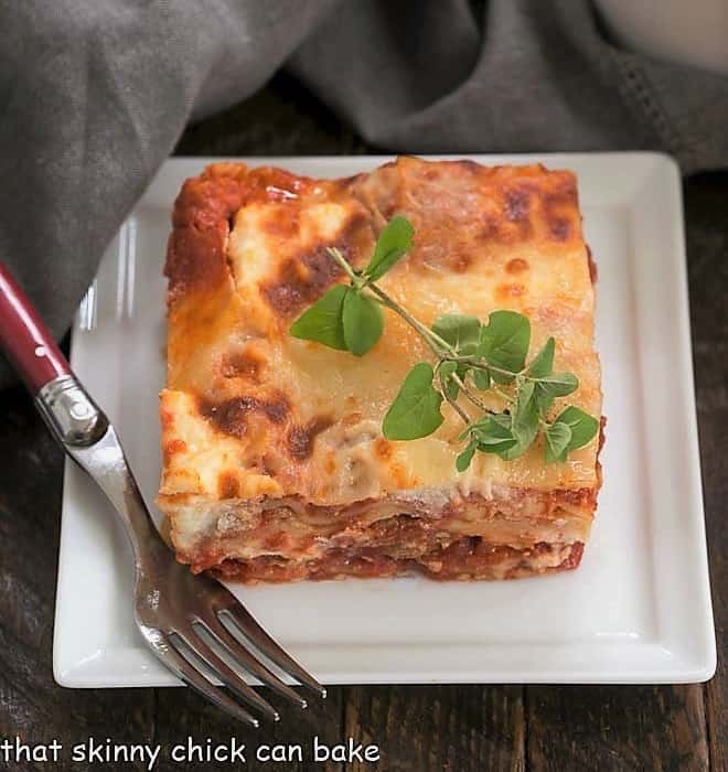 A slice of ricotta lasagna on a square white plate