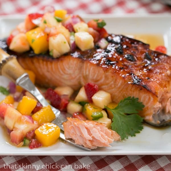Maple Glazed Salmon on a white plate with a forkful of salmon next to a larger piece of salmon