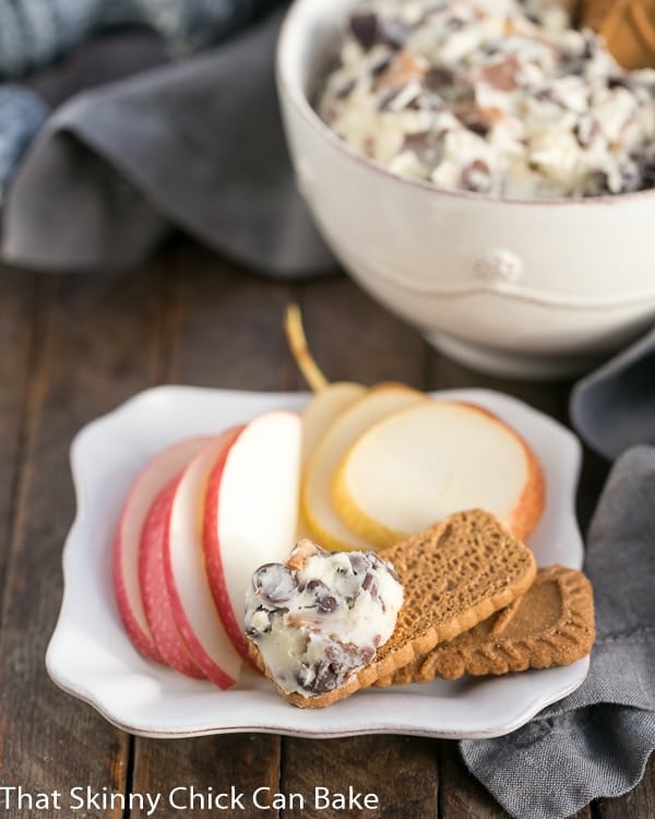 Chocolate Chip Cookie Dough Dip - A dreamy dip filled with chocolate chips and toffee pieces! Chocolate Chip Cookie Dough Dip on a square white plate with cookies, apple and pear slices.