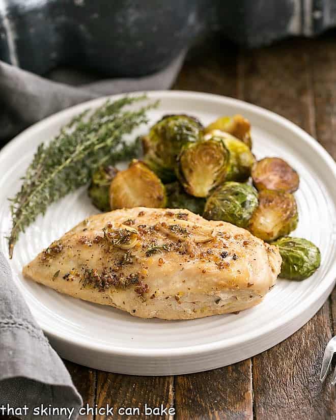Mustard Maple Chicken Breast on a white dinner plate with Brussels sprouts