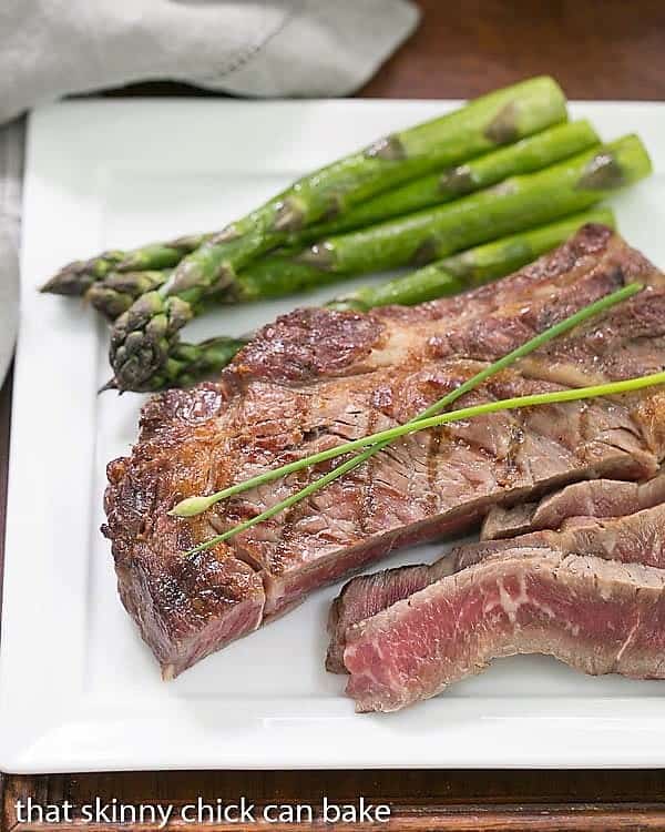 Tips for Grilling Steaks - Grilling tips for the best steaks at home! From how long to grill steak to how to season and prep for grilling. Sliced Perfect Grilled Rib Eye Steaks on a square white plate.