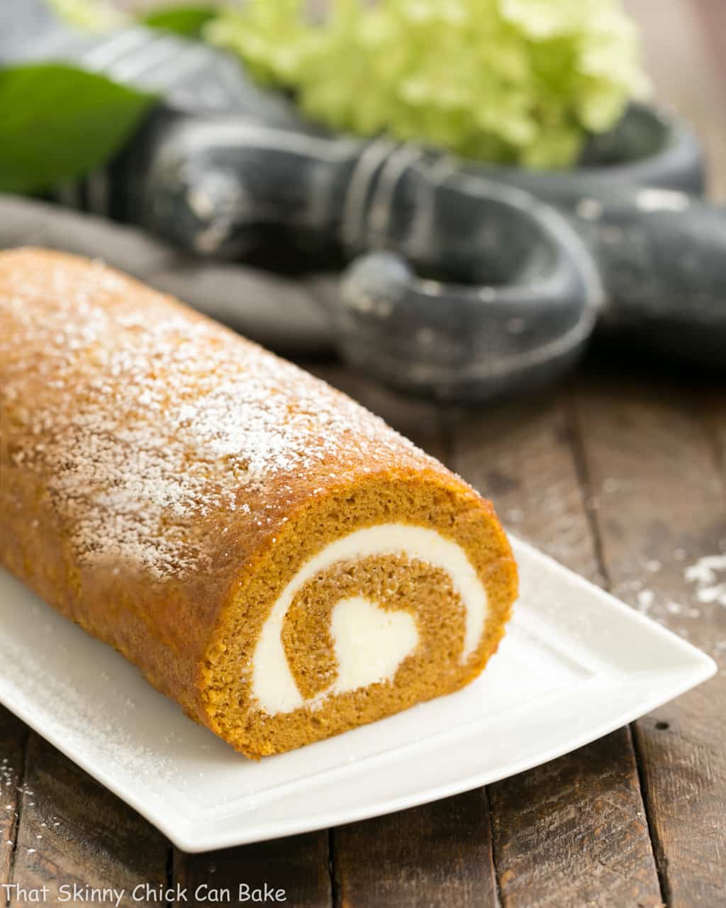 Old fashioned pumpkin roll recipe with cream cheese filling #pumpkin #cakeroll #roulade Old fashioned pumpkin roll on a rectangular serving tray.