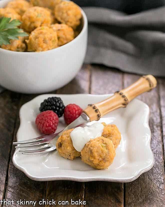 Buffalo chicken meatballs and berries on a white appetizer plate.