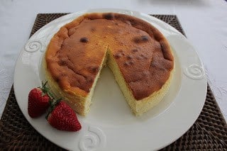 ricotta on a white plate with strawberries and a slice removed