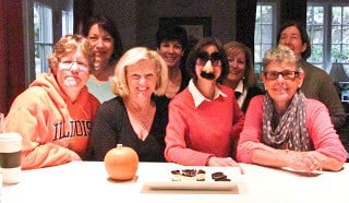 A group of friends sitting at the kitchen bar after a food demo of how to make cheesecake!