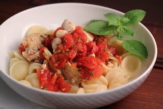 Chicken Feta Casserole - an easy, flavorful weeknight entree Chicken Feta Casserole in a white bowl with a sprig of basil