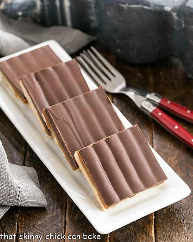 Homemade Twix Bars on a white ceramic tray.