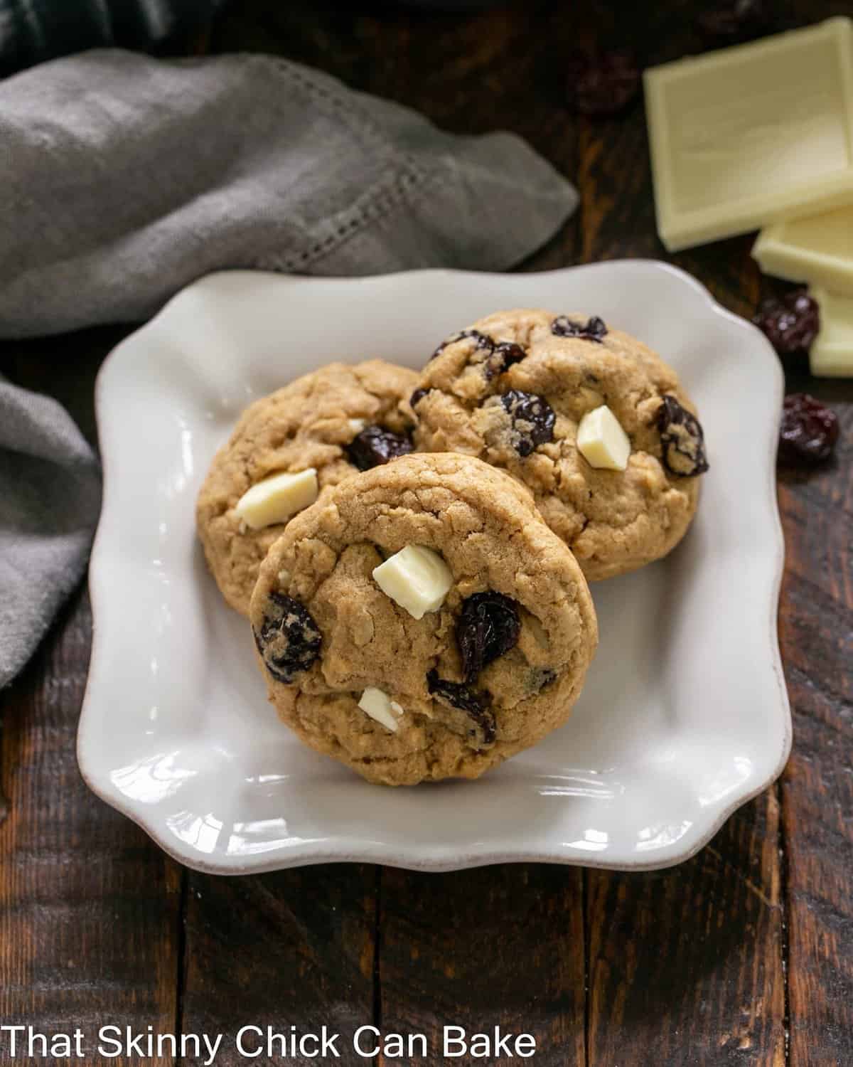 Oatmeal, Dried Cherry and White Chocolate Chunk Cookies on a square white plate.