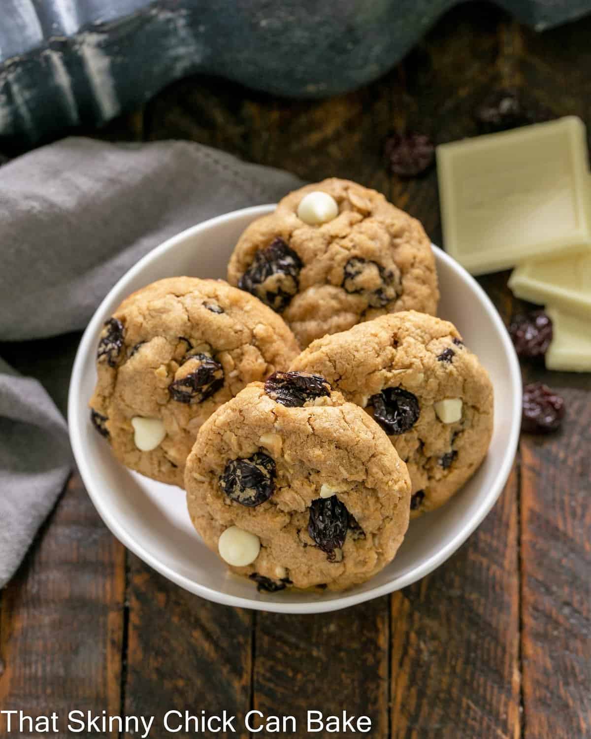 Overhead view of a small white bowl of cherry cookies.