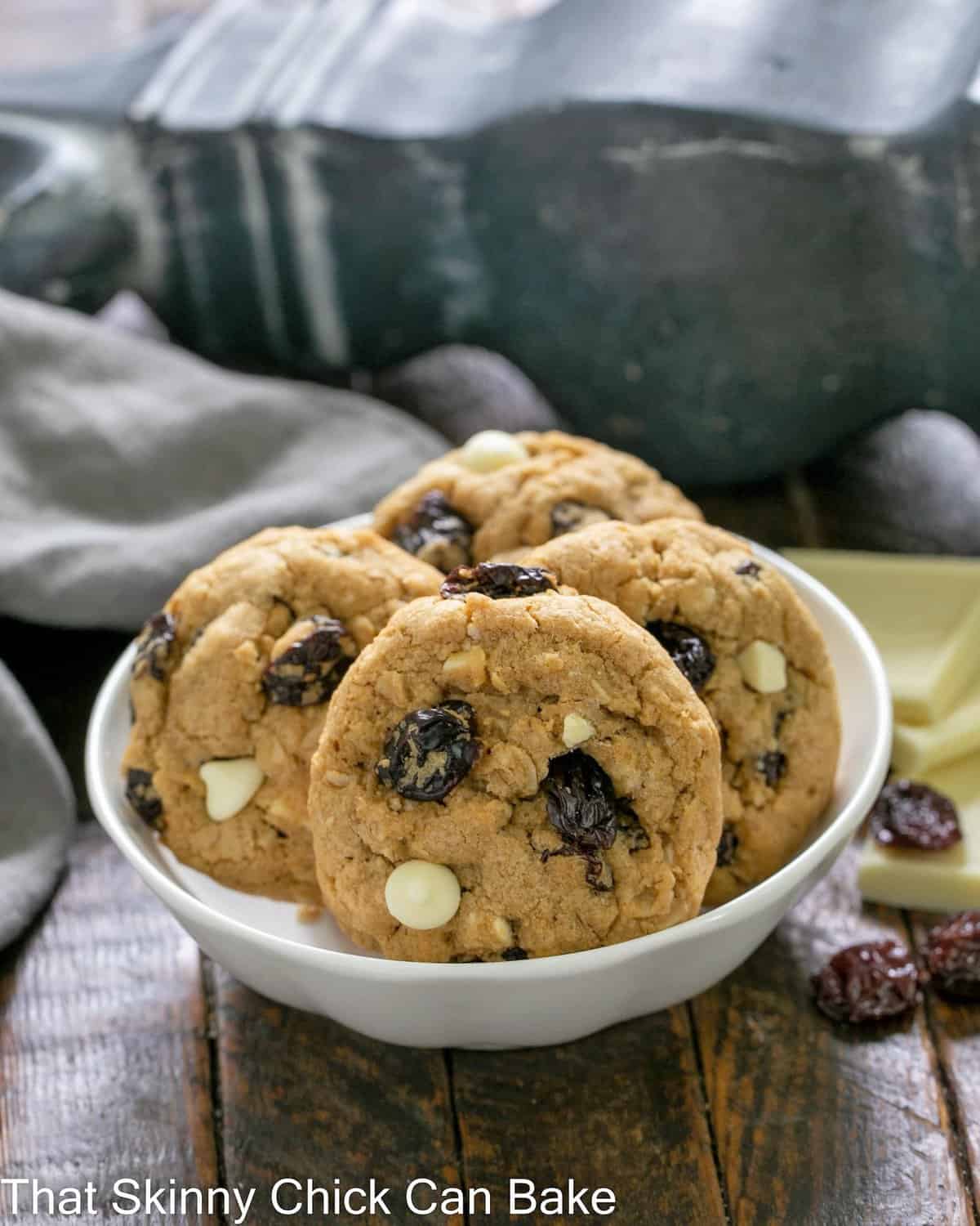 Oatmeal, Dried Cherry and White Chocolate Cookies in a small white bowl.