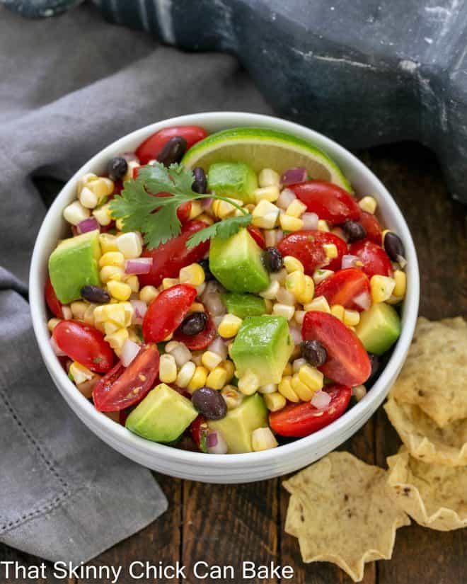 Overhead view ob black bean and corn salsa in a white serving dish with tortilla chips