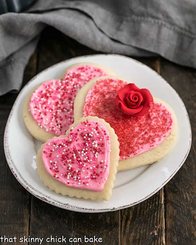 Lofthouse Cookies - the classic bakery Sugar Cookies baked up for Valentine's Day 3 Lofthouse cookies on a round white plate.