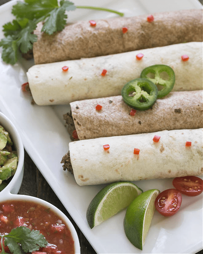 Soft Shell Beef Tacos - these ground beef tacos are made with a simple spice mixture plus garlic and onions. A quick and easy weeknight meal that's family friendly! Overhead view of soft shell beef tacos on a white platter.