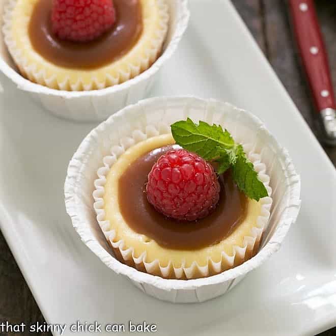 Caramel Topped Mini Cheesecakes - An exquisite combination of flavors and textures in these individual cheesecakes! Close overhead view of mini cheesecakes topped with caramel and mint.