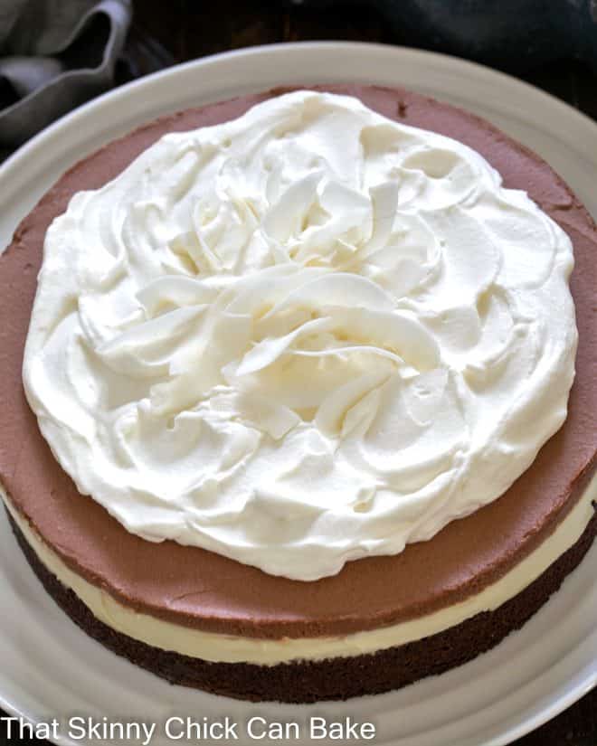 Close overhead view of a brownie coconut cream cake on a white plate