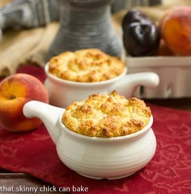 Peach and Plum Johnnycake Cobblers in white ceramic baking dishes.