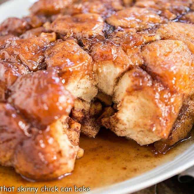 Crock Pot Apple Monkey Bread -- Breakfast dish made easy using canned biscuits and diced apples creating a gooey, cinnamon spiced caramel coating around each delicious bite! Apple Monkey Bread on a serving platter.