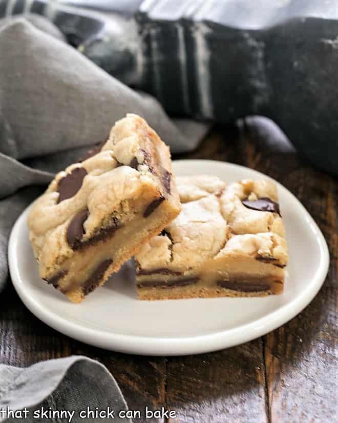 Caramel Chocolate Chip Cookie Bars - rich buttery cookie bars filled with chocolate and caramel sauce Two Caramel Chocolate Chip Cookie Bar on a small round white plate