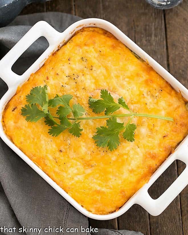 Chili Relleno Casserole - Layers of gooey cheese, eggs, tomatoes and peppers make for an irresistible Tex-Mex dish! Chili Relleno Casserole in a square white baking dish.
