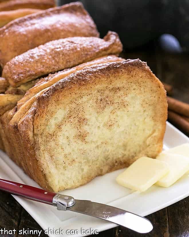 Cinnamon Pull Apart Bread on a white tray with a knife and butter pats.