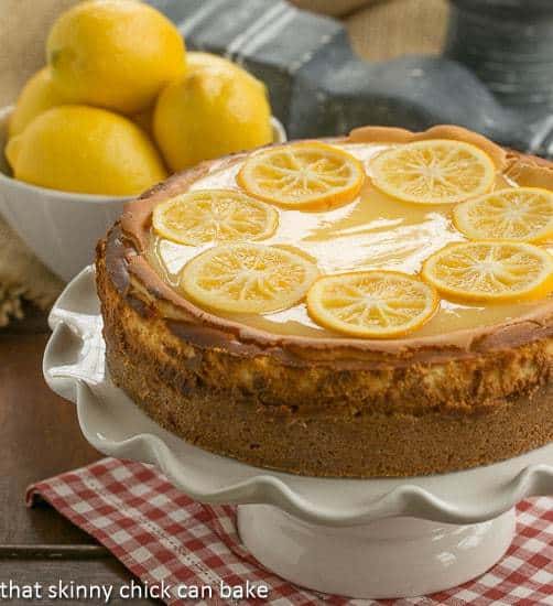 Lemon Bar Cheesecake on a white cake stand.
