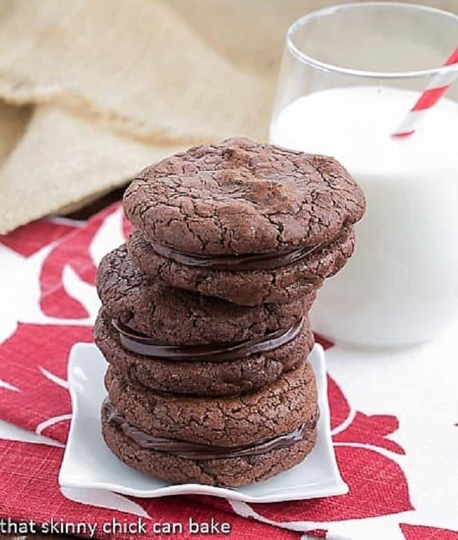 Stack of chocolate sandwich cookies on a small white plate.
