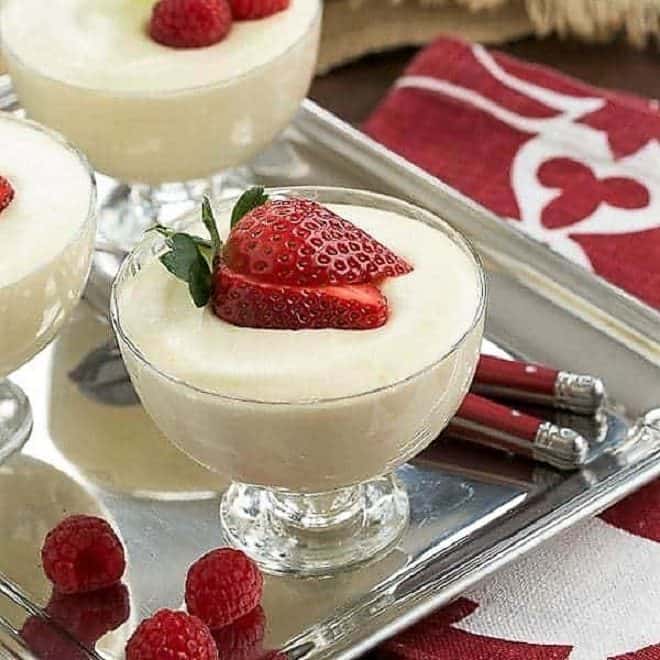 Dreamy White Chocolate Mousse spiked with Frangelico in glass dishes topped with berries.