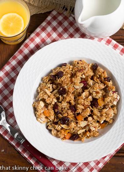 Chunky Maple Coconut Granola viewed from above in a white bowl over a red and white checked napkin.