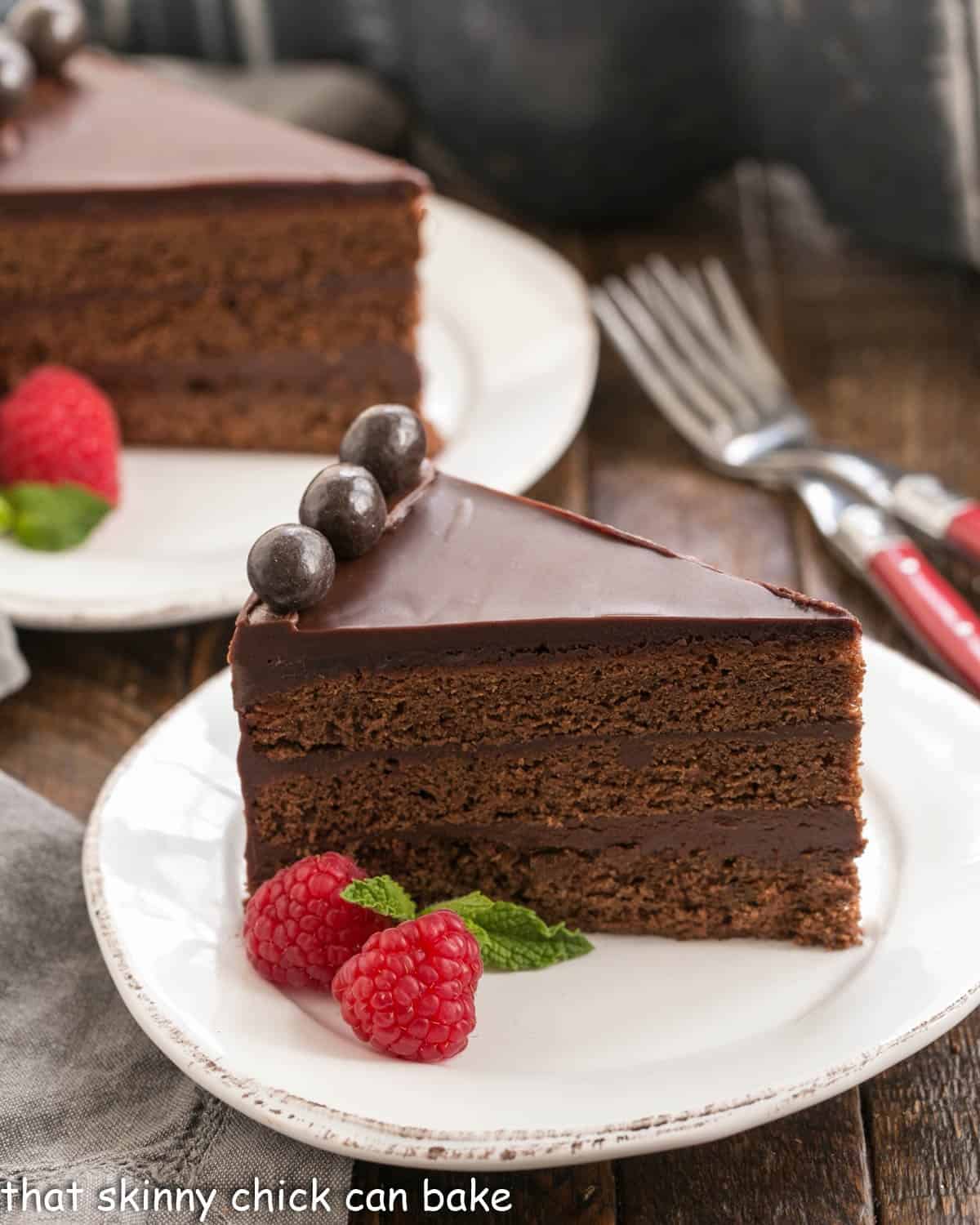 Slice of Mocha Brownie Cake on a white dessert plate with a second slice in the background.