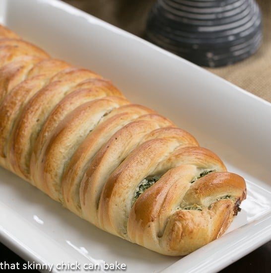Uncut Spinach and Onion Braid on a white ceramic tray.