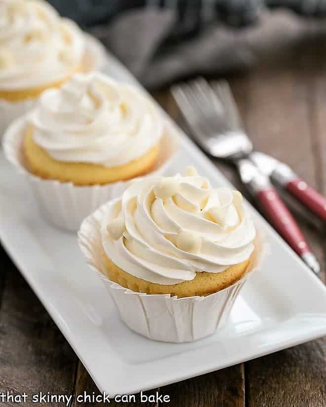 Ghirardelli Vanilla Cupcakes with White Chocolate Buttercream on a white ceramic tray.