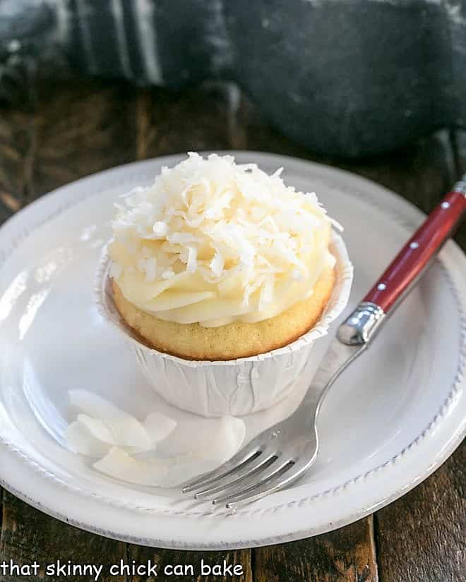 Coconut Cupcakes with Cream Cheese Frosting on a small white plate.