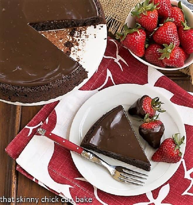 Flourless Double Chocolate Cake slice from above on a white plate with a red handled fork.