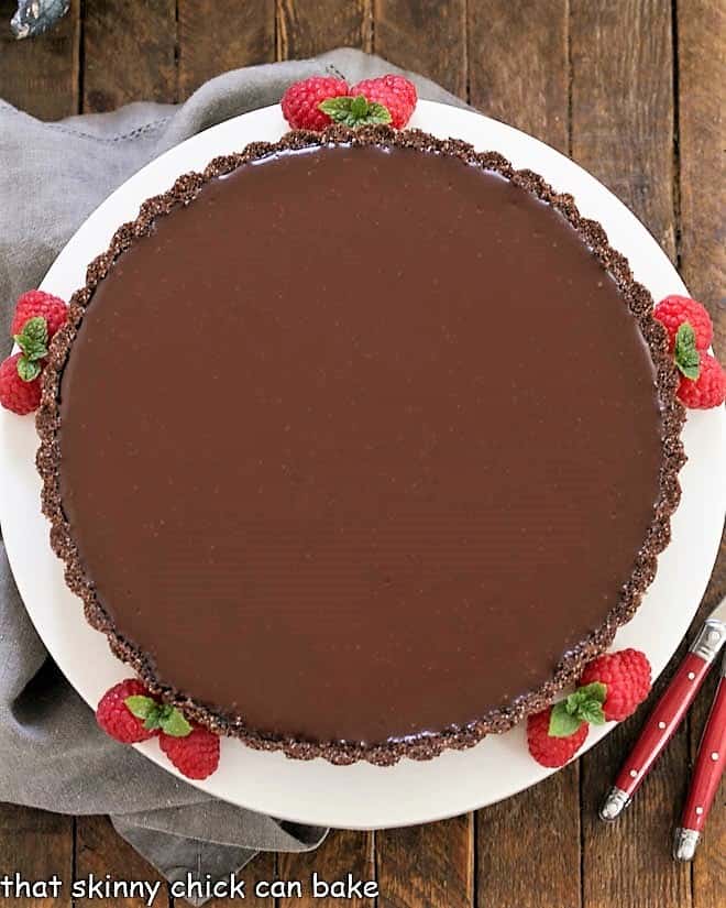 Ganache Topped Chocolate Tart overhead view on a white serving plate.