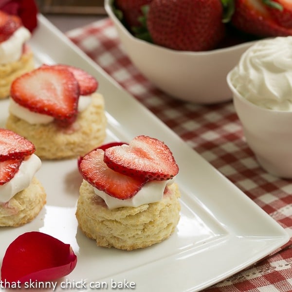 Double Strawberry Rose Shortcakes on a white ceramic tray garnished with rose petals.